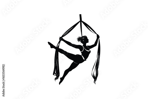 Graceful aerial acrobat performs a dynamic pose suspended in fabric silks during a captivating performance showcasing strength and flexibility in a striking silhouette