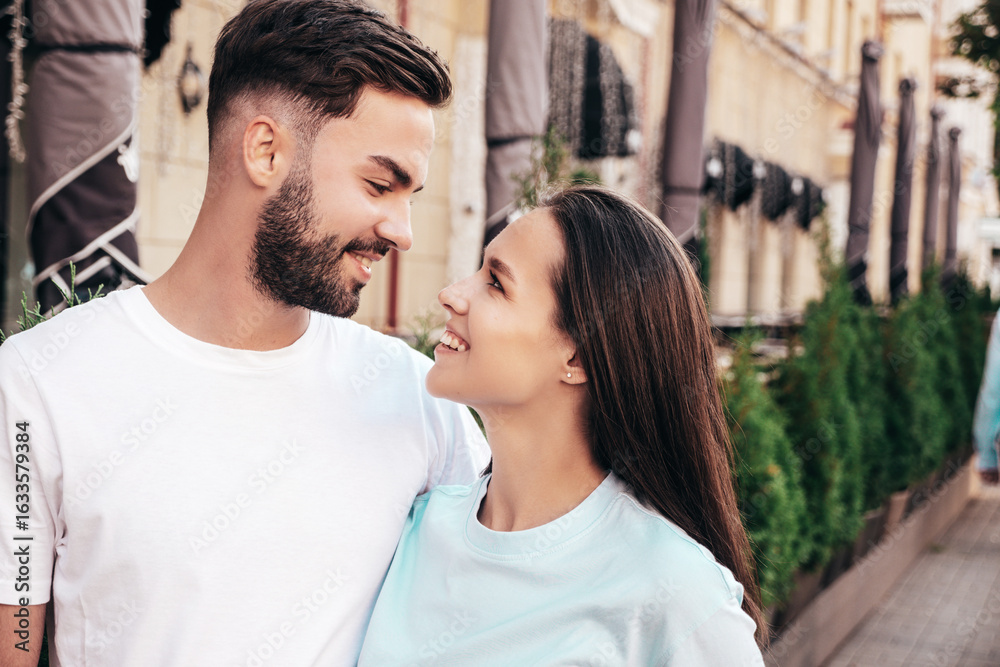 Fototapeta premium Smiling beautiful woman and her handsome boyfriend. Woman in casual summer jeans clothes. Happy cheerful family. Female having fun. Sexy couple posing in the street at sunny day