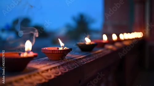 Row of Glowing Traditional Diya Oil Lamps on Ledge at Dusk