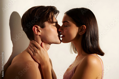 Young hispanic man and woman models are kissing with closed eyes and holding each other in a romantic and intimate moment, expressing love and passion