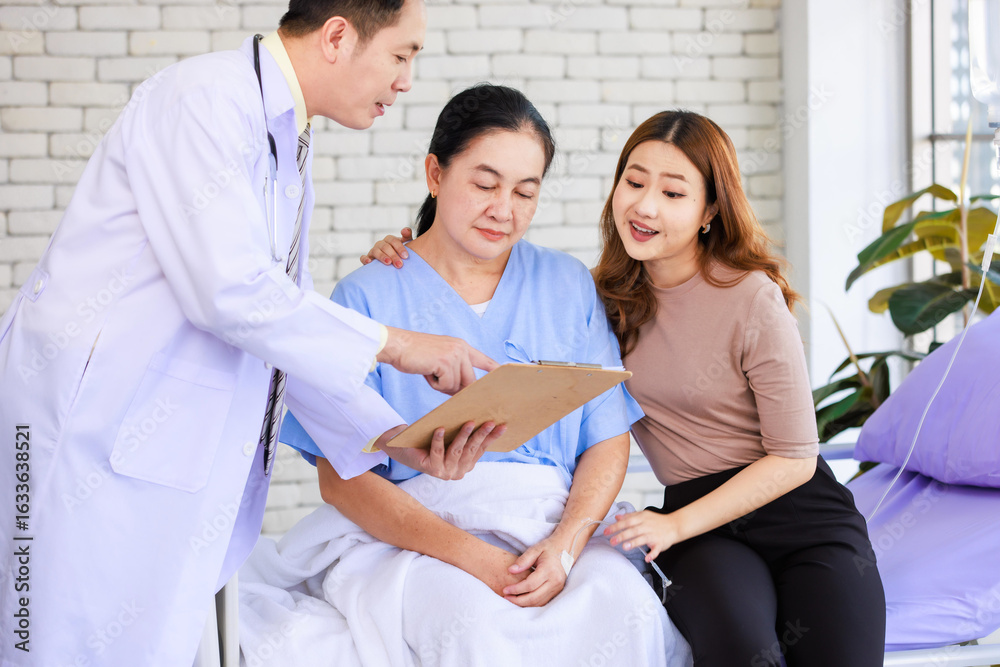 Asian man professional doctor visiting ward talking giving report good news to smiling and happy family and senior woman patient sitting on hospital bed with lovely daughter showing healthcare support Asian man professional doctor visiting ward talking giving report good news to smiling and happy family and senior woman patient sitting on hospital bed with lovely daughter showing healthcare support
