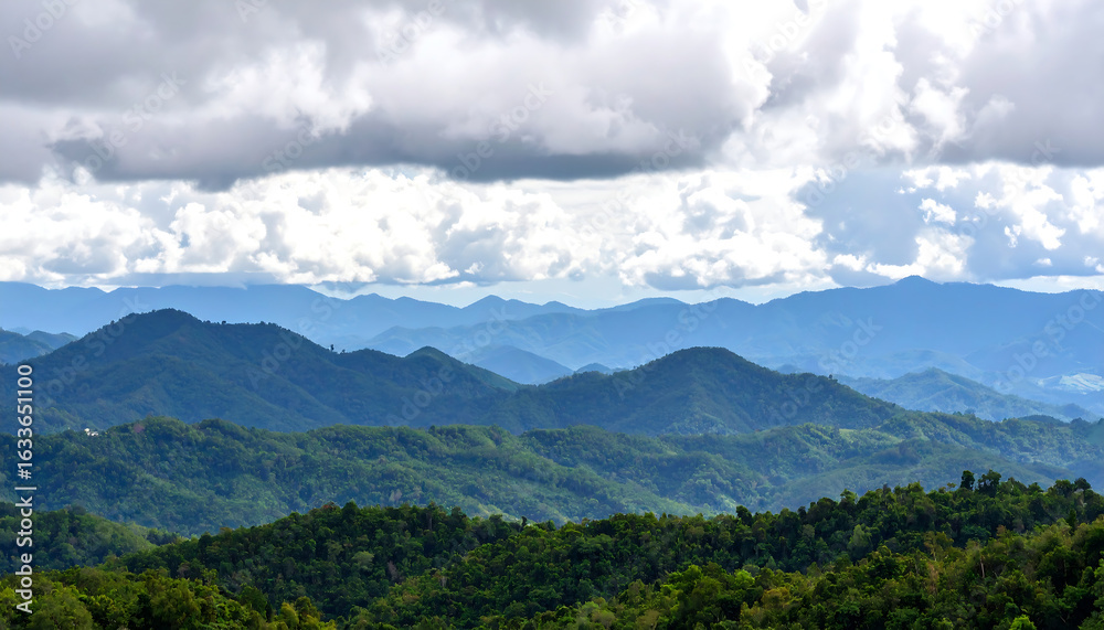 Fototapeta premium Breathtaking mountain landscape showcasing lush greenery and dramatic cloud formations, evoking sense of tranquility