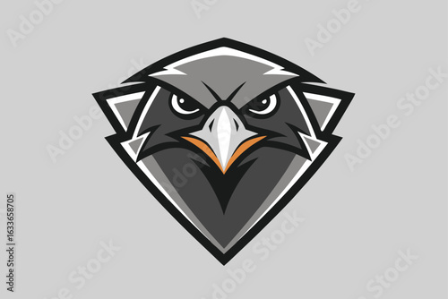 An intense falcon head faces forward in a crest shaped black, white, and gray shield