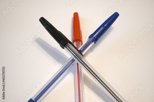 Wallpaper Mural Three pens – red, black, and blue – arranged on a white background. Stationery concept with copy space. Close-up view. Torontodigital.ca