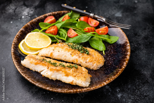 Canvas Print Roast Cod fish fiilets, white fish meat on plate with salad