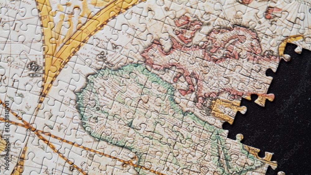 Fototapeta premium Unfinished global puzzle closeup. Antique styled map missing section on black