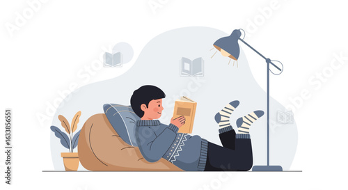 Boy Reading Book On Beanbag Chair Under Lamp In Cozy Home Environment