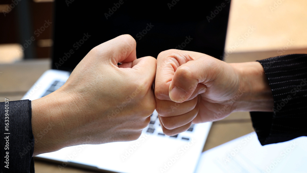 Fototapeta premium Deal of teamwork with the Man hand a fist bump commit as get together in the office