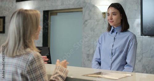 Woman frustrated for argument, mistake in hotel lobby. Conflict, customer and manager with dispute, angry booking crisis and upset with service.