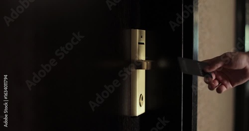 Close up of female hand open hotel room door with electronic card key. Protection and security system concept.