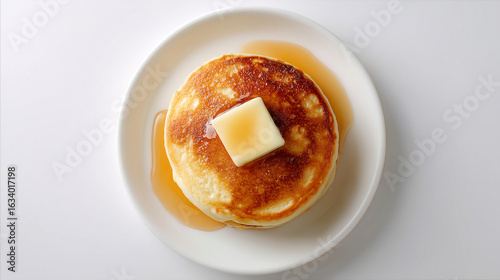 シンプルで美しいパンケーキにメープルシロップとバターが乗せられた俯瞰スタジオショット