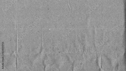 Grey kraft paper noise texture 4K stop motion video. Aged old page overlay effect background loop animation. Vintage paper texture with crease, stain, grain, dust particles. Empty animated backdrop
