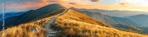 Mountain trail leading along the mountain ridge of beautiful mountains with autumn grass and colorful sky. 