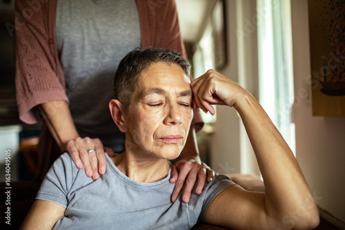 Stressed woman receiving comforting support from her lesbian partner at home