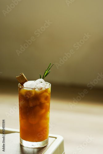 Slika na platnu Refreshing iced espresso and orange juice, topped with cinnamon and rosemary Colors and tones complement each other