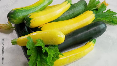 Top view of colorful zucchini of different sizes on a light background. Ideal for healthy eating and vegan dishes. Close-up, top view. Organic zucchini, yellow zucchini, green zucchini