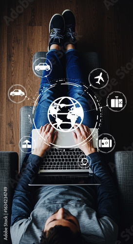 A person sitting in a chair and using a laptop, surrounded by glowing holographic travel icons like an airplane, car, and suitcase, representing online travel booking and planning.