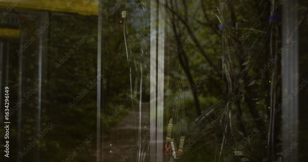 Fototapeta premium Showing tangled black cables behind glass cabinet at forest with zip-ties reflection, copy space