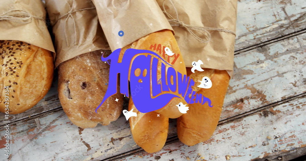 Fototapeta premium Displaying paper-wrapped loaves on chipped blue wooden table showing Halloween ghost graphic