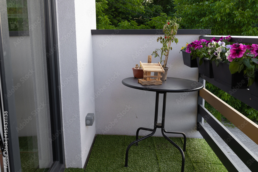 Fototapeta premium Small outdoor balcony garden with table and potted plants