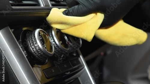 employee is using a microfiber cloth to clean a car.