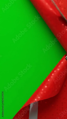 Red gift wrap unwrapping to reveal a vibrant green screen background, perfect for holiday unboxing videos, festive surprises, and customizable promotional content.

