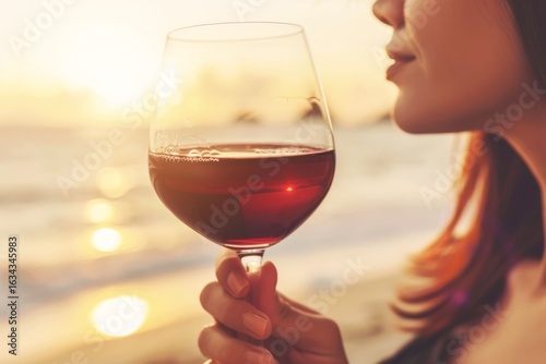 Enjoying a sunset by the beach while sipping red wine in a tranquil moment of relaxation and reflection