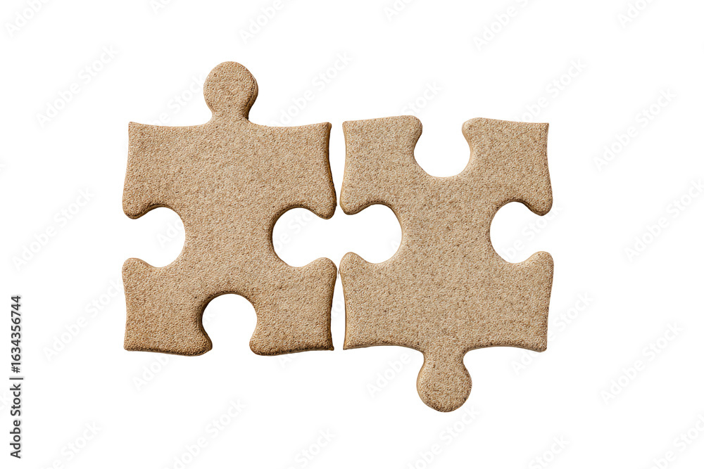 Fototapeta premium Two light beige puzzle pieces, closely joined, on a black background