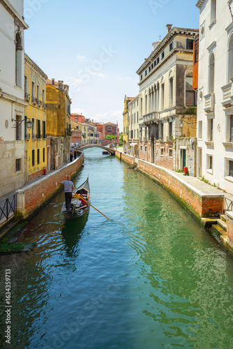 View of the unique and characteristic Venetian canals, where typical boats knew as Gondola are used for tourist sightseeing. Worldwide famous, Venezia is a unique kind of city and UNESCO site.