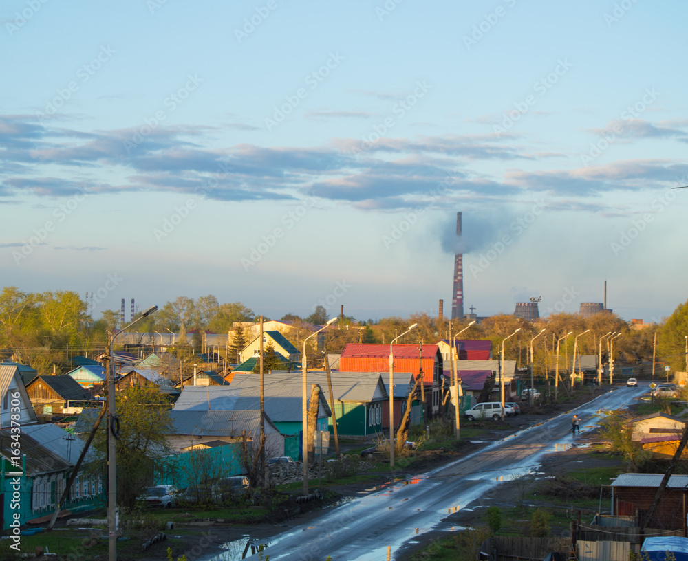 Obraz premium Smoke from the chimneys of boiler house in city near houses, problems of ecology
