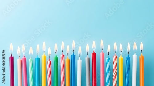 Colorful birthday candles on gradient blue, celebrating joy with overhead soft light and shallow focus.