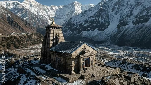 Majestic Stone Temple Adorned With Snow Amidst Himalayan Mountain Range Under Clear Azure Sky In Kedarnath