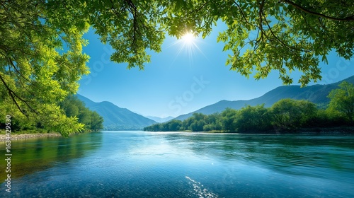 夏の青空と新緑の山々、穏やかに流れる川の風景
