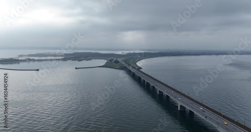 Wallpaper Mural the Great Belt Bridge curving over a body of water toward a landmass under a cloudy sky in Denmark Torontodigital.ca