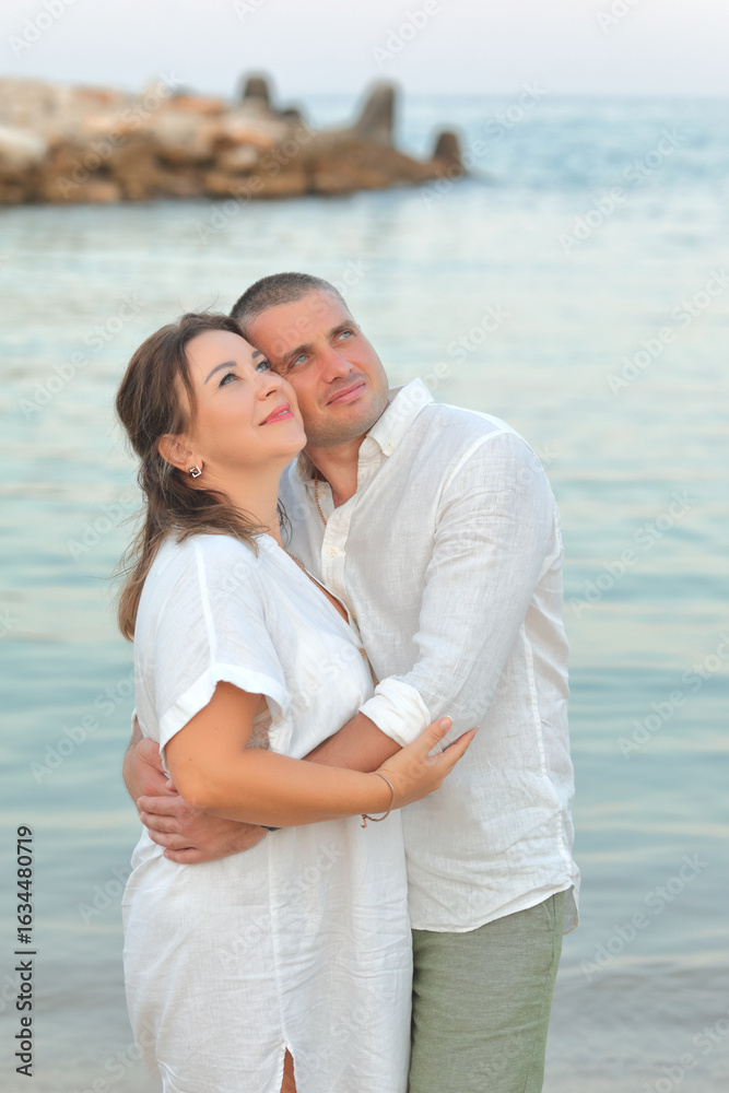 Obraz premium Couple in love at sea on the beach in summer. Husband and wife. Dad and mom