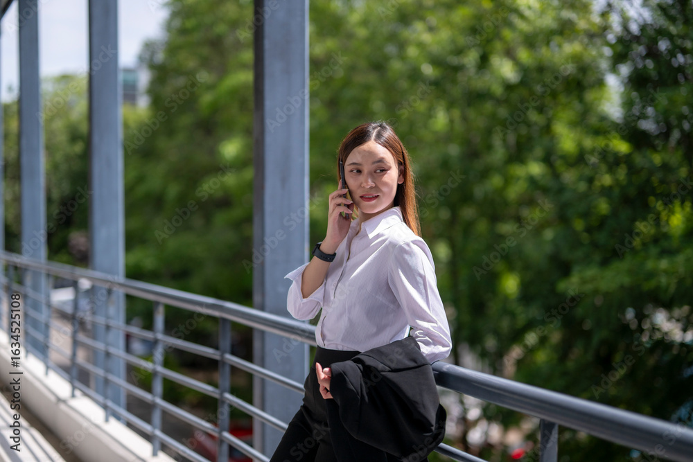Obraz premium Businesswoman talking on phone on modern walkway
