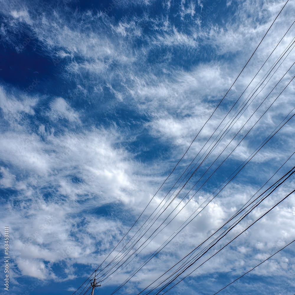 Naklejka premium Power lines against a vibrant sky filled with wispy clouds
