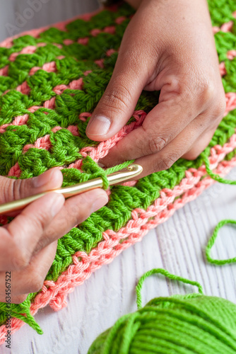 Hands of a Latin woman knitting with crochet