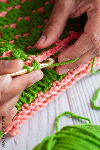 Hands of a Latin woman knitting with crochet