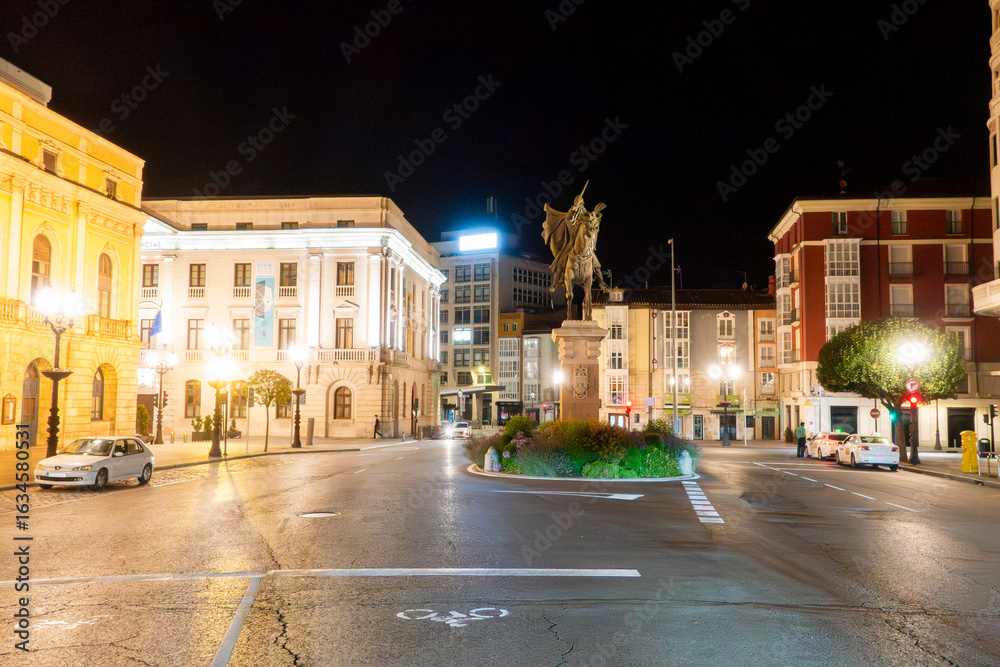 Obraz premium Urban cityscape of Burgos at night with illuminated historic buildings, Spain.