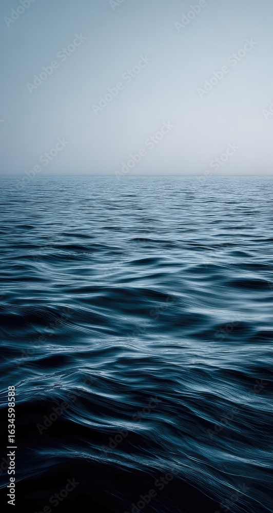 Obraz premium Calm, dark ocean surface, subtle waves. A vast, misty horizon