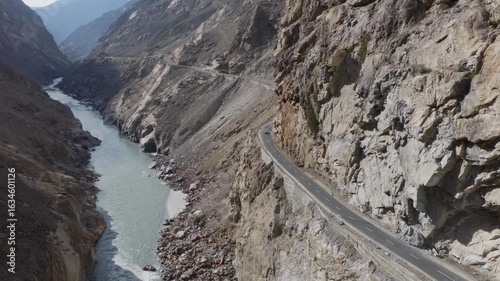 Aerial view of a winding road through a dramatic canyon in Pakistan, highlighting the stark beauty of the natural landscape
