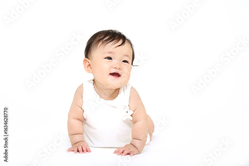 白背景の前をハイハイする赤ちゃんの正面クローズアップ