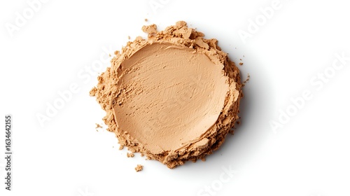 A circular powder of foundation with a smooth texture, surrounded by loose powder, ideal for makeup application.