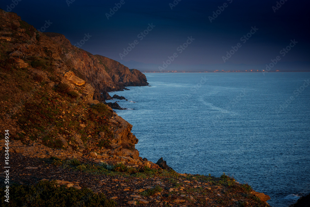 Fototapeta premium Sunrise in Catalan country, at Cap Béar, reflected in the sea surrounded by rocks at Port Vendres in the south of France. 