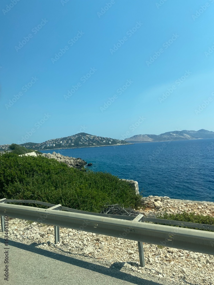Obraz premium Mediterranean coast and beautiful blue bay view. Cruise ship sailing calm sea. Summer travel and tourism concept for holiday. Turkey. Greece 