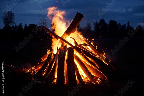 A large bonfire burns on Midsummer Eve in Latvia.
Bright bonfire flame on the rural field at evening