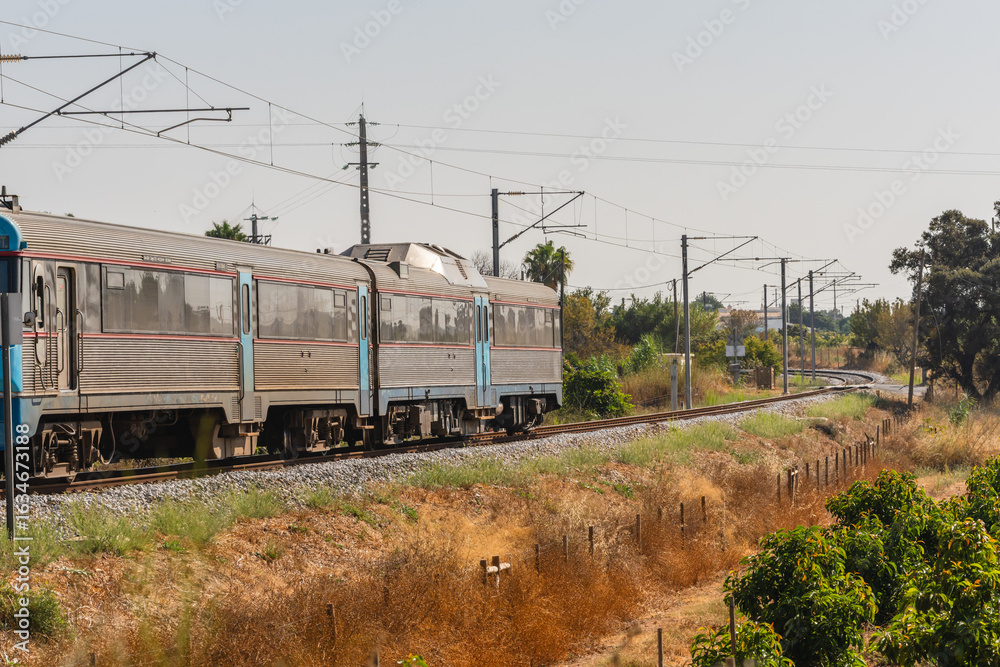 Naklejka premium Train traveling through countryside on curved railway