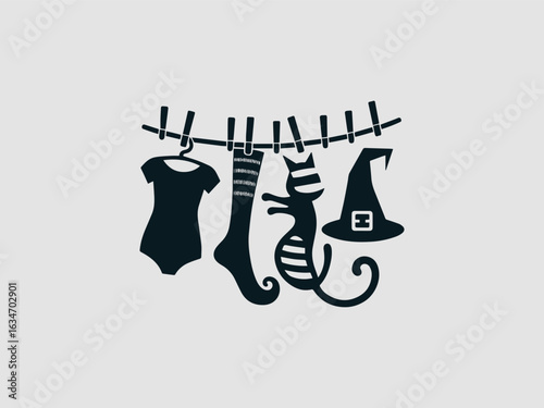 A funny black cat, a witch hat, shoes, and striped socks hanging on a clothesline for halloween