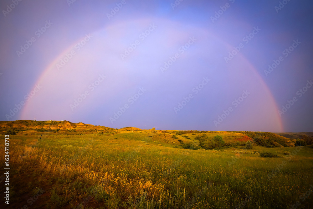 Naklejka premium Beautiful Sunset Rainbow on Open Grassland